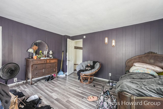 bedroom featuring light wood-type flooring and wood walls