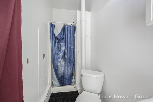 bathroom featuring a baseboard radiator, toilet, and curtained shower