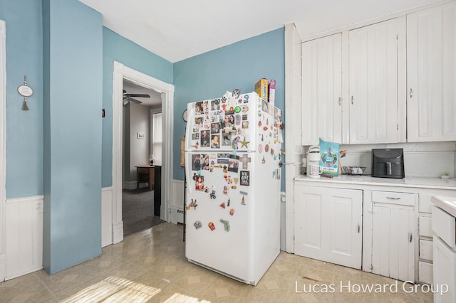 kitchen featuring white cabinetry, ceiling fan, and white refrigerator