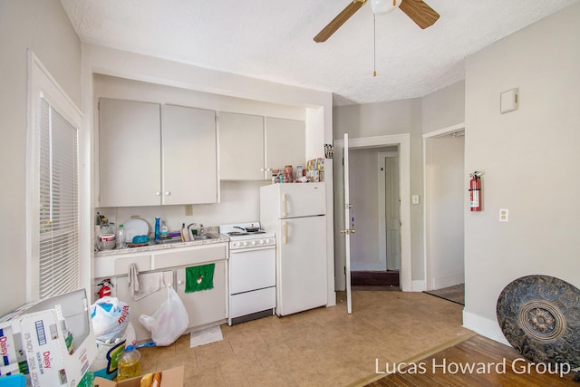 kitchen featuring a textured ceiling, white cabinetry, ceiling fan, and white appliances