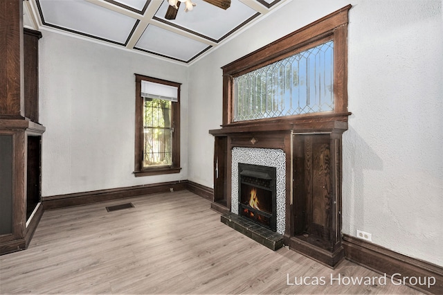 unfurnished living room featuring a fireplace, light hardwood / wood-style floors, ceiling fan, and coffered ceiling