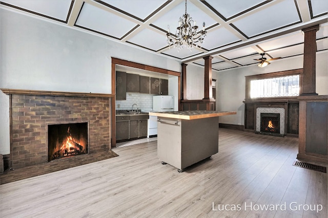 kitchen featuring decorative backsplash, light wood-type flooring, coffered ceiling, dark brown cabinets, and ceiling fan