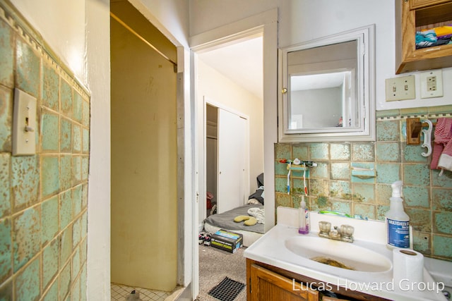 bathroom featuring vanity, a shower, and tile walls