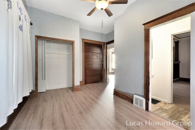 unfurnished bedroom with ceiling fan, a closet, and light hardwood / wood-style floors