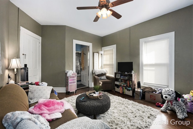 living room featuring ceiling fan and dark hardwood / wood-style flooring