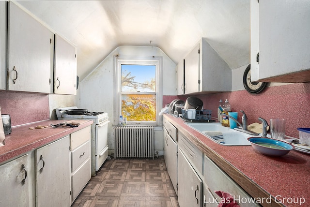 kitchen featuring dark parquet floors, sink, vaulted ceiling, radiator heating unit, and white range with gas cooktop