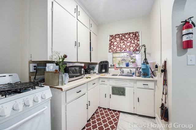 kitchen featuring white cabinetry, sink, and gas range gas stove