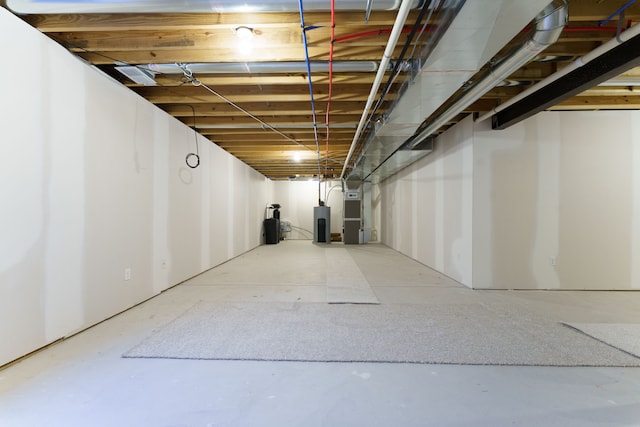 basement featuring electric water heater and heating unit