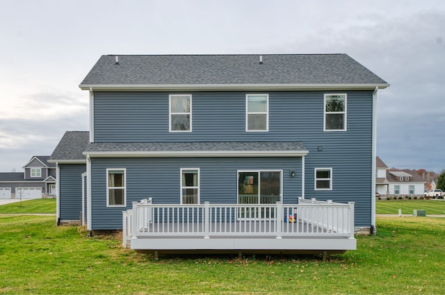 rear view of house with a lawn and a wooden deck