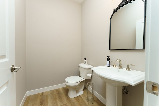 bathroom with hardwood / wood-style flooring and toilet