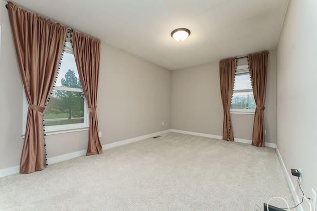 carpeted spare room with a healthy amount of sunlight