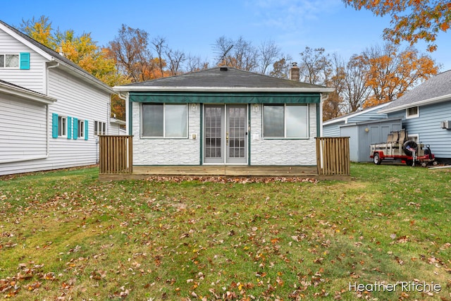 rear view of house with a wooden deck and a yard