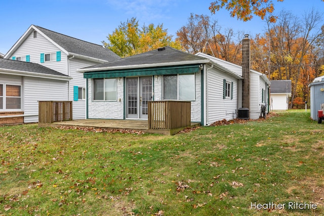 rear view of property featuring a sunroom, a storage unit, cooling unit, and a yard