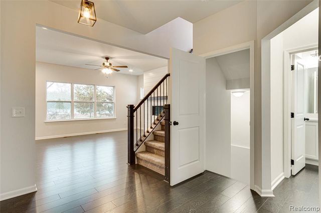 stairway featuring ceiling fan and hardwood / wood-style flooring