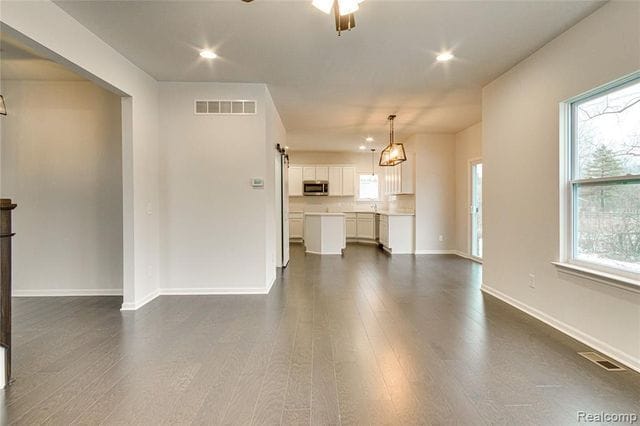 unfurnished living room with plenty of natural light and dark hardwood / wood-style floors