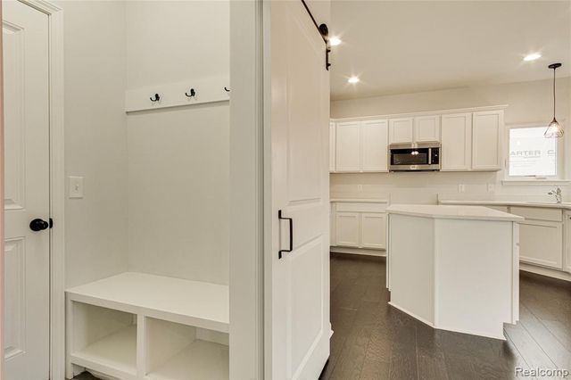 kitchen featuring a center island, white cabinets, dark hardwood / wood-style floors, and decorative light fixtures