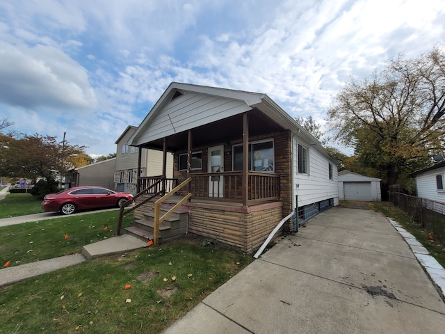 bungalow-style home with a front lawn, an outdoor structure, and a garage