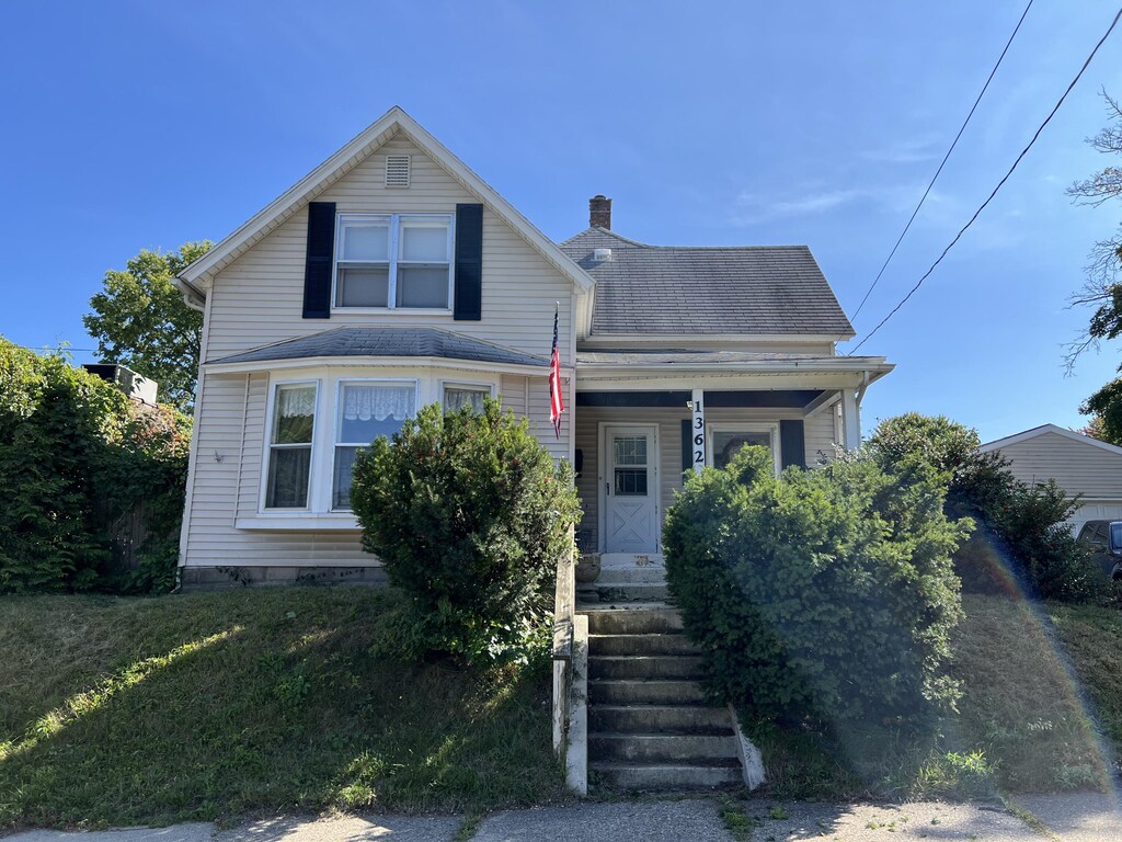 1362 Leonard St NW, Grand Rapids, MI 49504 - view of front facade featuring a chimney, covered porch, and roof with shingles