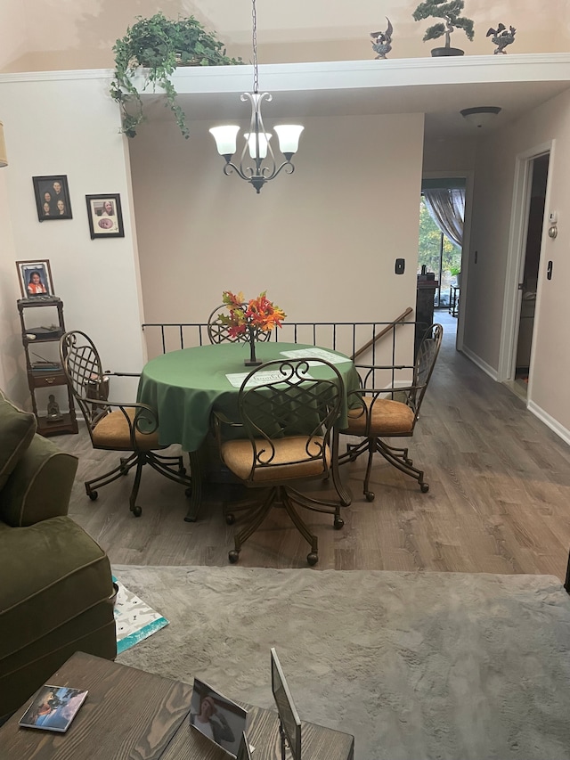 dining room with hardwood / wood-style floors and a notable chandelier