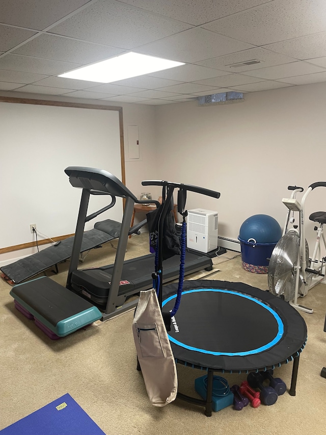 exercise room featuring carpet flooring, a drop ceiling, baseboard heating, and electric panel