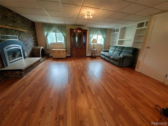 unfurnished room featuring hardwood / wood-style floors, plenty of natural light, and a drop ceiling