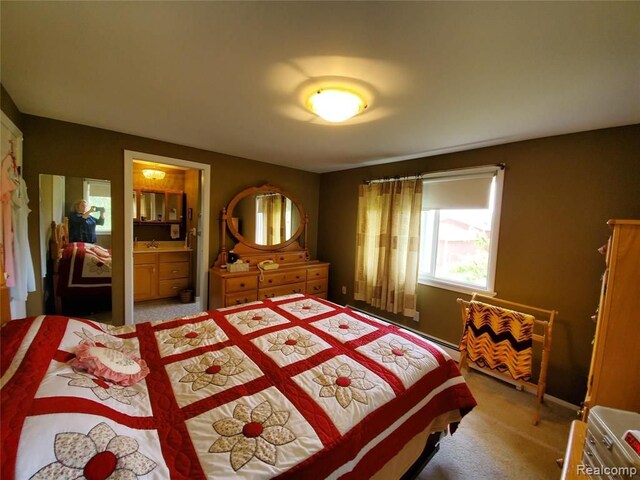 bedroom with light colored carpet and connected bathroom