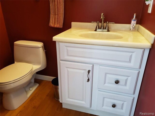 bathroom featuring hardwood / wood-style flooring, vanity, and toilet