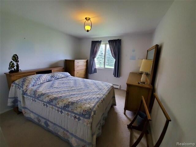 carpeted bedroom featuring a baseboard heating unit