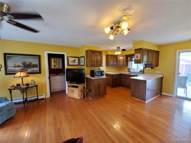 kitchen with a kitchen island, baseboard heating, and light hardwood / wood-style flooring