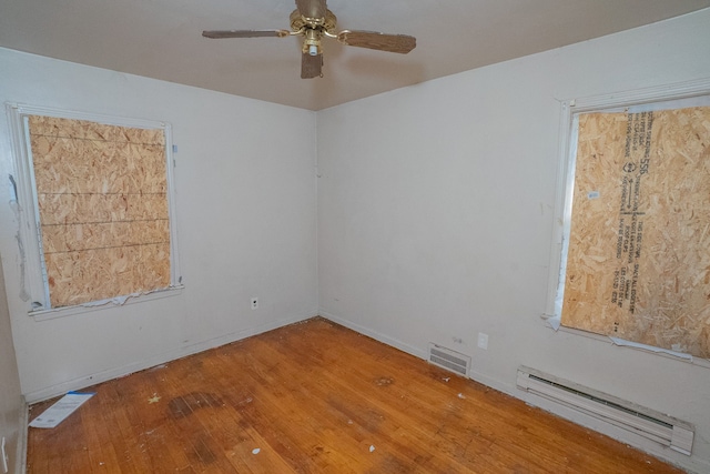 empty room featuring ceiling fan, a baseboard radiator, and hardwood / wood-style flooring