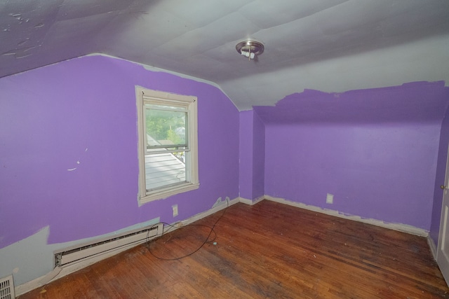 additional living space featuring wood-type flooring, lofted ceiling, and a baseboard heating unit