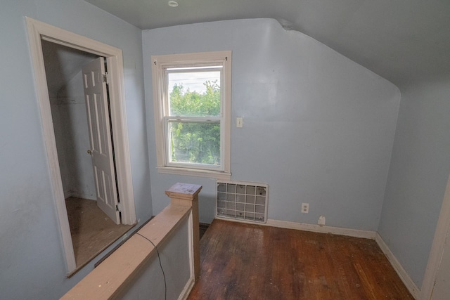 additional living space featuring vaulted ceiling and dark hardwood / wood-style floors