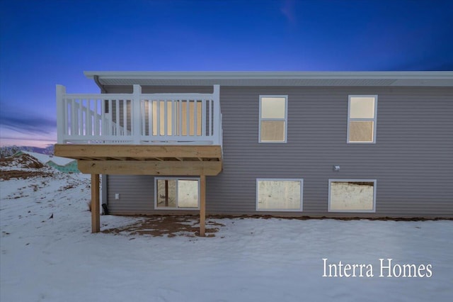 snow covered house with a wooden deck