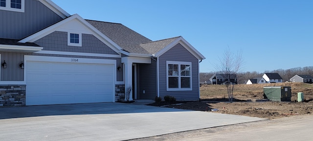 view of front facade featuring stone siding, board and batten siding, and concrete driveway