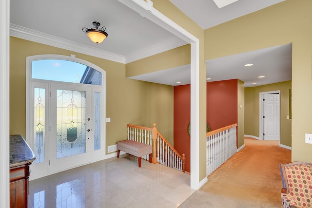 foyer entrance with ornamental molding and light carpet