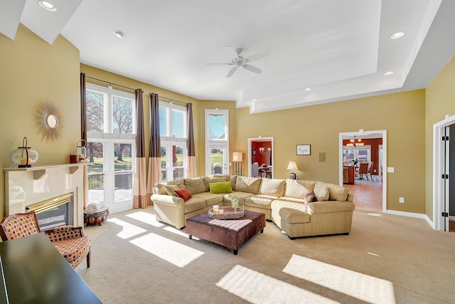 carpeted living room featuring a fireplace and ceiling fan