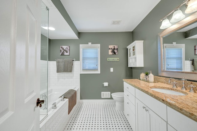 bathroom featuring vanity, toilet, and tiled bath