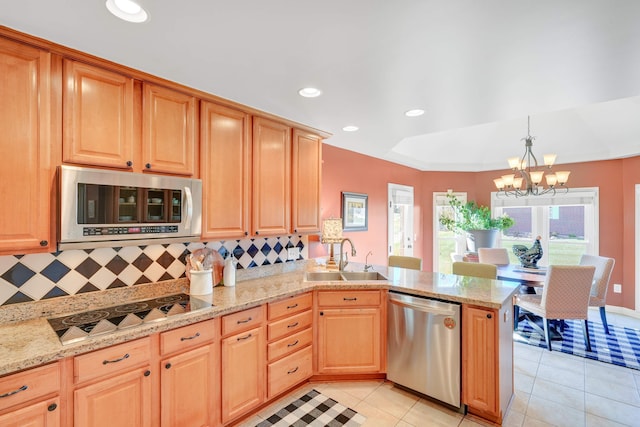 kitchen featuring sink, hanging light fixtures, tasteful backsplash, a notable chandelier, and appliances with stainless steel finishes