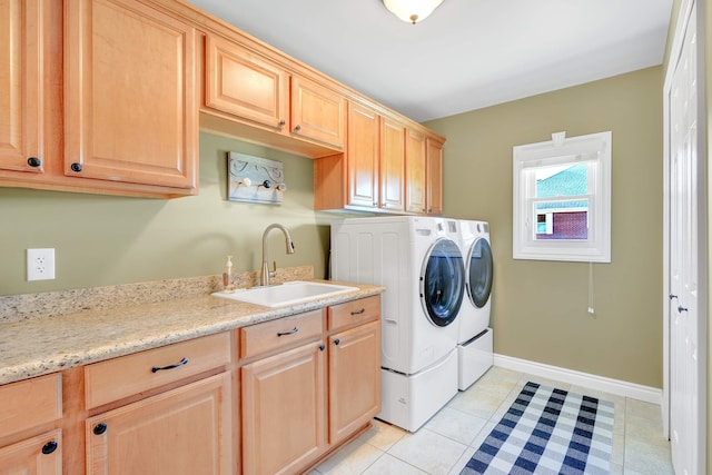 laundry room featuring washer and dryer, light tile patterned flooring, cabinets, and sink