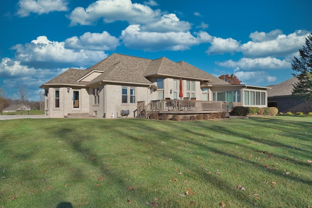 back of house featuring a yard, a sunroom, and a wooden deck