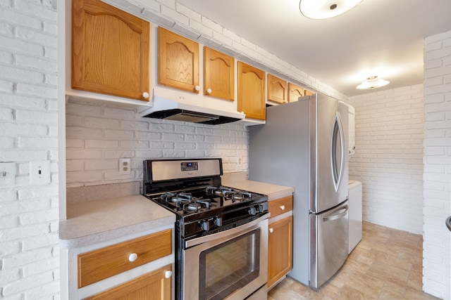 kitchen featuring stainless steel appliances and brick wall