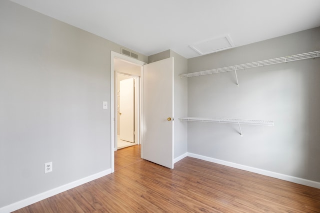 unfurnished bedroom with hardwood / wood-style floors and a closet