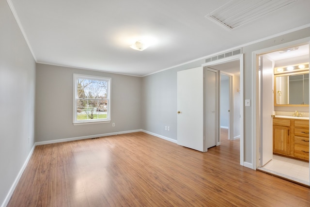 spare room with hardwood / wood-style flooring, sink, and crown molding