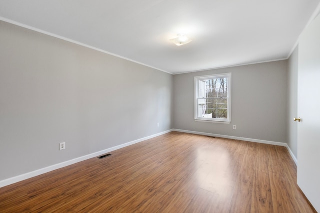 unfurnished room featuring hardwood / wood-style floors and ornamental molding