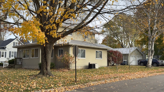 view of home's exterior featuring an outbuilding, a yard, a garage, and central AC unit