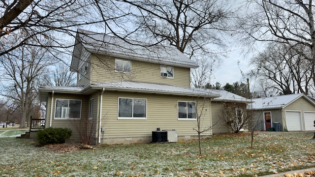 exterior space with a garage, an outdoor structure, a yard, and central AC