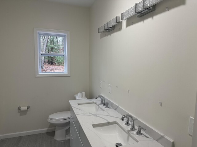 1820 S Reid Rd, Custer, MI 49405 - bathroom with toilet, baseboards, and double vanity