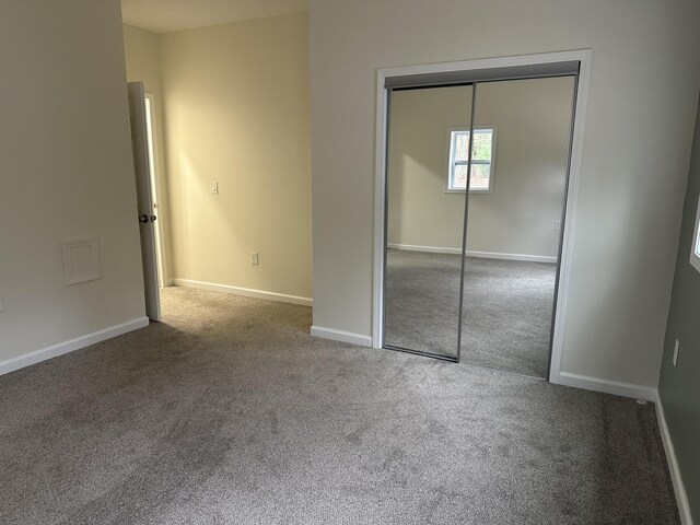 1820 S Reid Rd, Custer, MI 49405 - unfurnished bedroom featuring carpet flooring, a closet, and baseboards