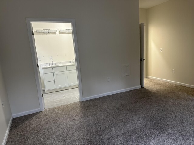 1820 S Reid Rd, Custer, MI 49405 - empty room featuring a sink, light carpet, and baseboards
