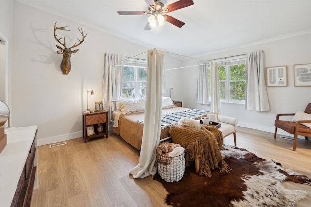 bedroom with light wood-type flooring, ceiling fan, and crown molding